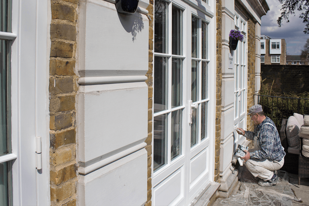 Workman finishing an exterior painting job in London